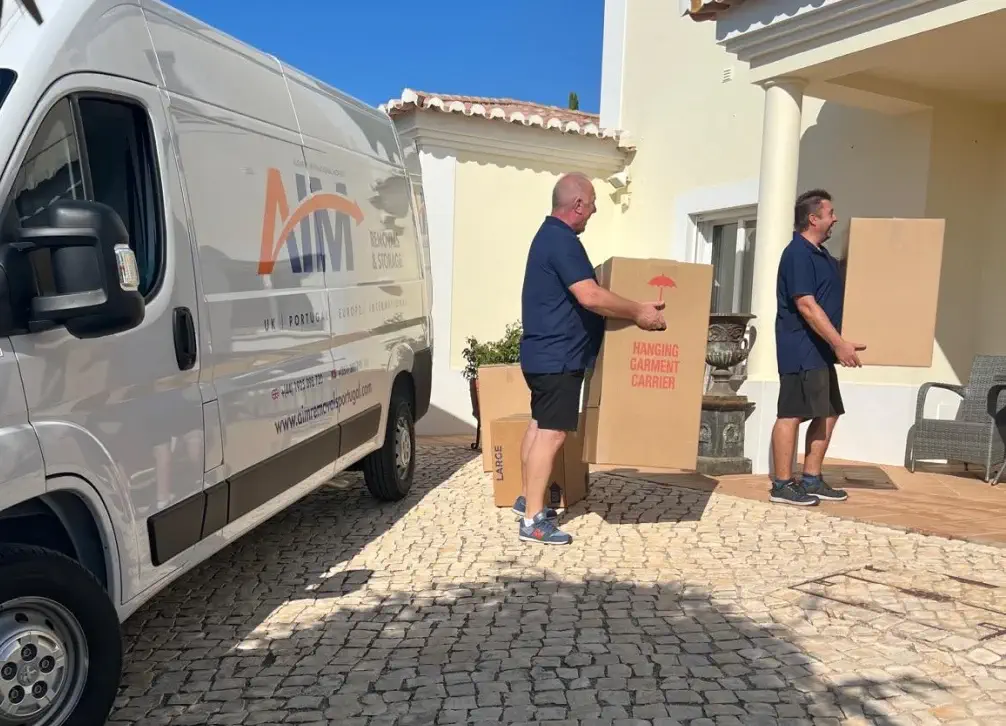 Professional movers transporting boxes from a van.